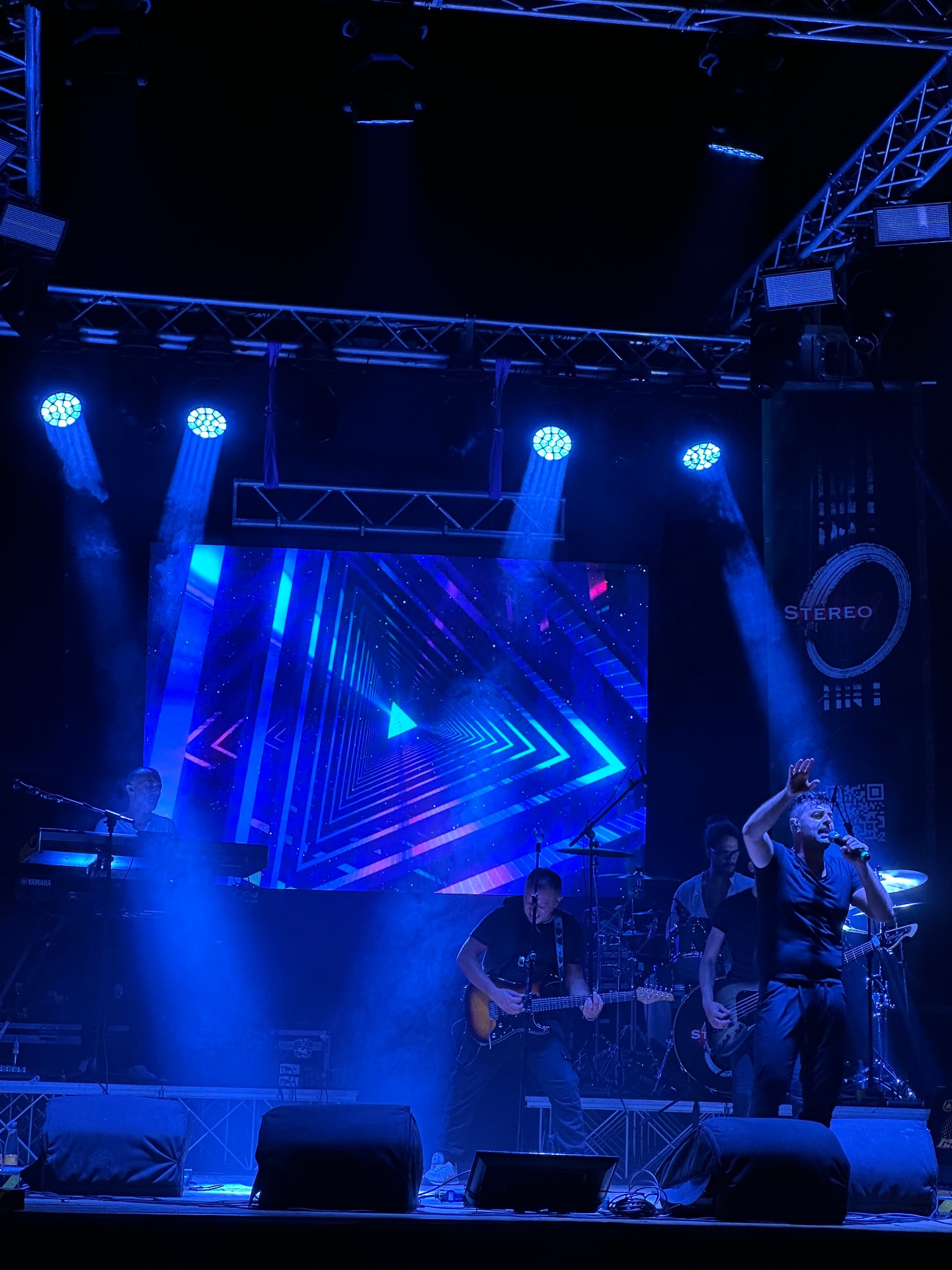 Stereo8 dal vivo: la band sul palco con le grafiche blu sullo schermo