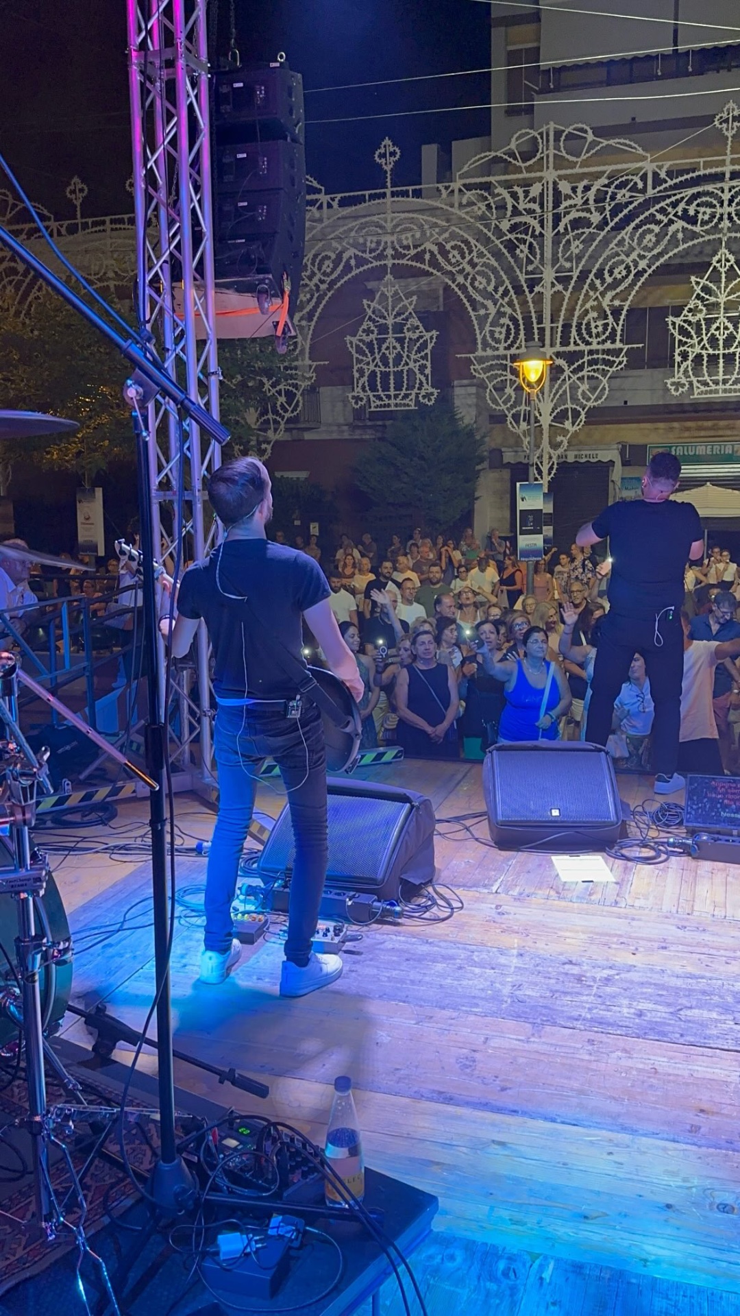 Stereo8 dal vivo: la band vista da dietro il palco davanti alla piazza con le luminarie