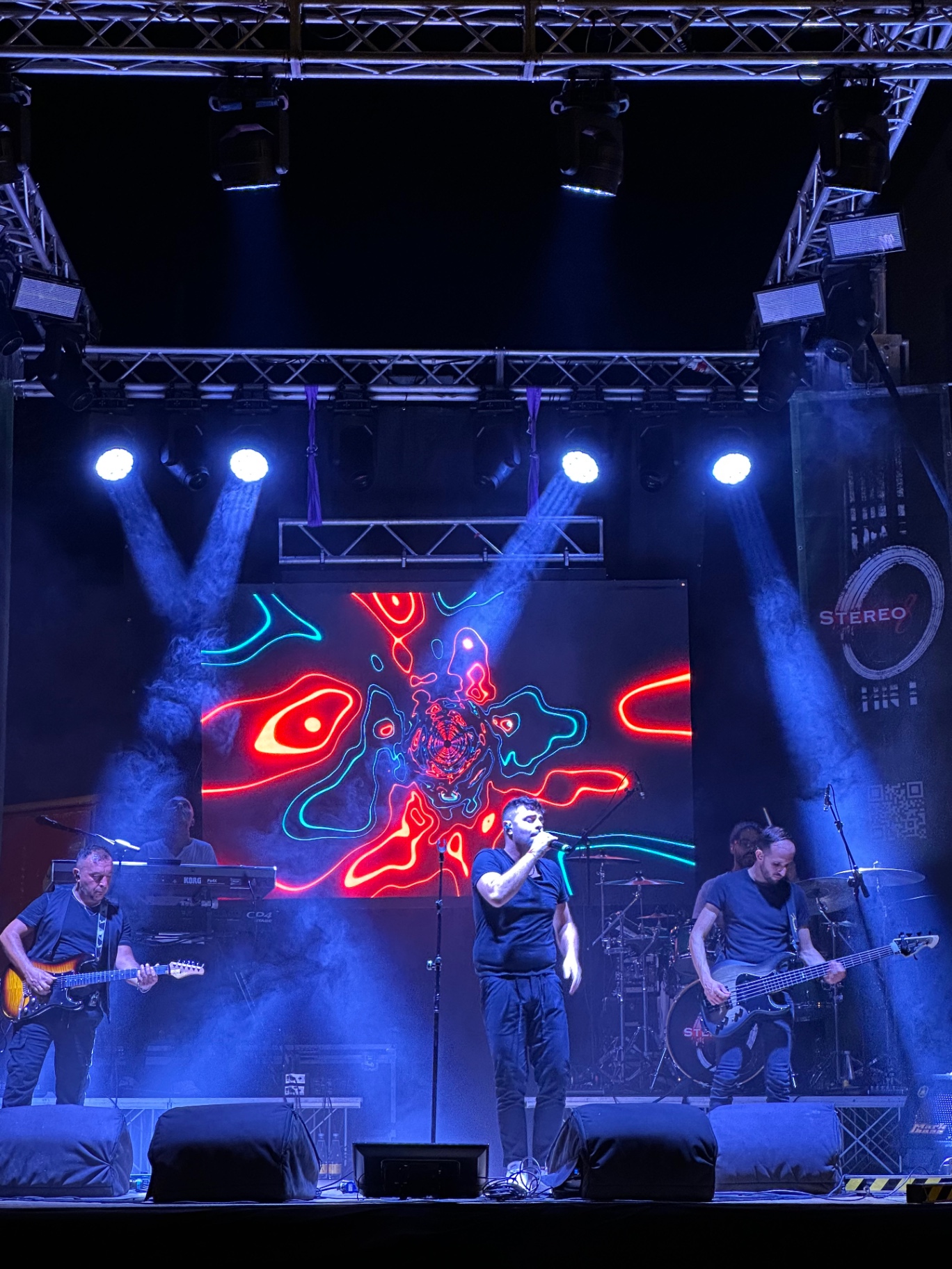 Stereo8 dal vivo: la band sul palco con le grafiche neon rosse e blu